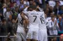 Real Madrid's Chicharito, left, celebrates his goal with Real Madrid's Cristiano Ronaldo, centre, and team mates during a Spanish La Liga soccer match between Real Madrid and Eibar at the Santiago Bernabeu stadium in Madrid, Spain, Saturday, April 11, 2015. (AP Photo/Andres Kudacki)