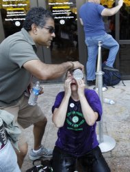One demonstrator helps another flush her eyes with water after after police pepper-sprayed a group of protestors, who were trying to get into the National Air and Space Museum in Washington Saturday, Oct. 8, 2011, as part of Occupy DC activities in Washington. (AP Photo/Jose Luis Magana)