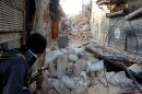 Un combatiente opositor sirio en una calle de la parte vieja de Alepo el lunes, enfrentándose entre escombros