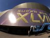 In this photo taken with a fisheye lens, workers put up signage outside the Superdome where tomorrow's NFL Super Bowl XLVII football game between the San Francisco 49ers and Baltimore Ravens will be played, Saturday, Feb. 2, 2013, in New Orleans. (AP Photo/Charlie Riedel)