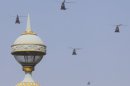 Helicopters fly in formation over the Champs Elysees avenue during a Bastille Day celebration in Paris, Sunday, July 14, 2013. (AP Photo/Jacques Brinon)