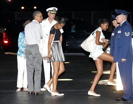 U.S. President Barack Obama (2nd L) and his daughters Malia (C) and Sasha (3rd R) board Air Force One upon their departure from Honolulu to return to Washington after a two-week vacation in Hawaii January 4, 2014. REUTERS/Kevin Lamarque