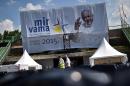Workers walk past a banner with a picture of Pope Francis at Sarajevo city stadium on June 5, 2015, a day ahead of the his visit