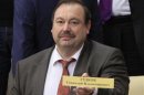 Member of the Just Russia political party Gudkov holds up name plate during a session of the Duma, Russia's lower house of parliament, in Moscow