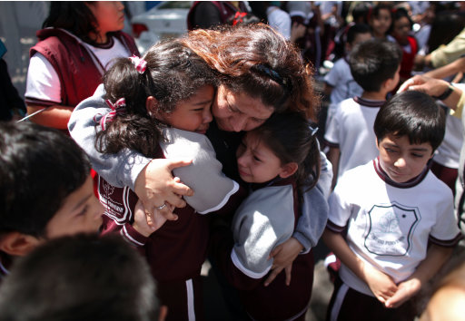 A woman comforts her children outside a school at the Roma neighborhood after a earthquake felt in Mexico City Tuesday March 20, 2012. A strong, long earthquake with epicenter in Guerrero state shook central southern Mexico on Tuesday, swaying buildings in Mexico City and sending frightened workers and residents into the streets..(AP Photo/Alexandre Meneghini)