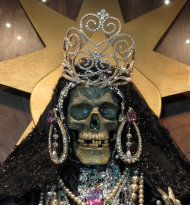 In this Feb. 12, 2013 photo, a statue of La Sante Muerte from an altar run by Arely Vazquez Gonzalez, a Mexican immigrant and transgender woman, is shown at inside a Queens, NY apartment. La Santa Muerte, an underworld saint most recently associated with the violent drug trade in Mexico, now is spreading throughout the U.S. among a new group of followers ranging from immigrant small business owners to artists and gay activists. In addition to showing up at drug crime scenes, the once-underground icon has been spotted on passion candles in Richmond, Va. grocery stores. The folk saint's image can be seen inside New York City apartments, in Minneapolis religious shops and during art shows in Tucson, Ariz. (AP Photo/Russell Contreras)