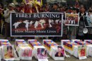 Tibetans offer prayers near mock coffins for the victims self-immolation during a rally in Siliguri on February 8