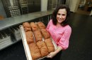 In this Thursday, July 14, 2012 photo, Michele Kelly, owner of Pure Knead bakery, poses with a rack of freshly baked gluten-free sandwich bread in Decatur, Ga. A research team led by the Mayo Clinic's Dr. Joseph Murray looked at blood samples taken from Americans in the 1950s and compared them to samples taken from people today, and determined celiac disease, triggered by gluten, has been increasing, confirming estimates that about 1 percent of U.S. adults have it today, Murray and his colleagues reported Tuesday, July 31, 2012. (AP Photo/John Bazemore)