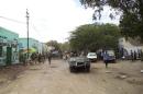 Somali government soldiers gather at the scene of a suicide bomb attack within a military base tea shop in Baladweyne