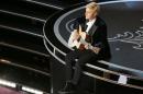 Host Degeneres plays a guitar at the 86th Academy Awards in Hollywood