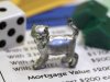 The newest Monopoly token, a cat, rests on a Boardwalk deed next to a die and houses at Hasbro Inc. headquarters, in Pawtucket, R.I., Tuesday, Feb. 5, 2013. Voting on Facebook determined that the cat would replace the iron token. (AP Photo/Steven Senne)