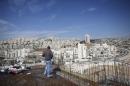 A labourer stands on an apartment building under construction in a Jewish settlement known to Israelis as Har Homa and to Palestinians as Jabal Abu Ghneim