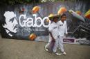 Residents walk next to a poster of Colombian Nobel laureate Gabriel Garcia Marquez, before a symbolic public funeral held for Garcia Marquez, in Aracataca