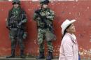 Soldiers stand guard as a woman walks past during a congressional election in Toribio in Cauca province