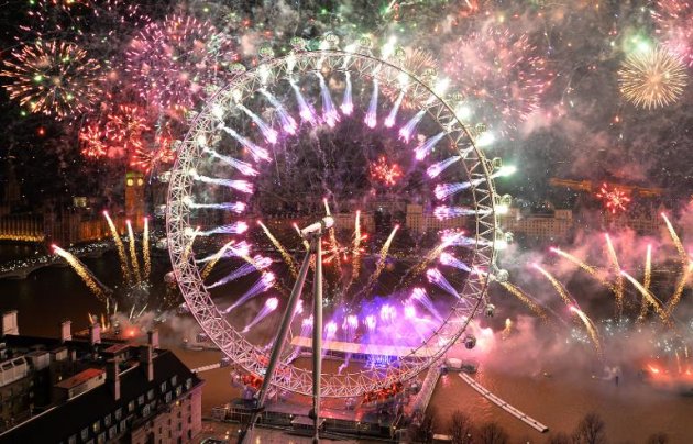 Fireworks light up the sky above the London Eye and the Houses of Parliament over the river Thames during the New Year celebrations in London