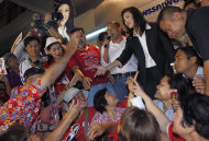 Yingluck Shinawatra, opposition Pheu Thai Party's candidate for prime minister shakes hands with supporters as she celebrates after winning the election at the party headquarters in Bangkok on Sunday, July 3, 2011. The sister of exiled former Prime Minister Thaksin Shinawatra, Yingluck led Thailand's main opposition party to a landslide victory in elections Sunday, heralding an extraordinary political turnaround five tumultuous years after her fugitive billionaire brother was toppled in an army coup, and paving the way Yingluck Shinawatra, who has never held office, to become this Southeast Asian kingdom's first female prime minister. (AP Photo/Vincent Yu)