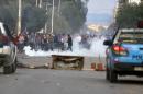 Protesters stand in tear gas during clashes with police outside the local government office in Kasserine