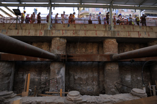 Arqueólogos y directivos de la empresa que construye el metro de Tesalónica, la segunda ciudad más grande de Grecia, muestran a los medios de comunicación y ciudadanos las ruinas de un camino pavimentado en mármol y construido por los romanos hace casi 2.000 años, en esta fotografía del lunes 25 de junio de 2012. (Foto AP/Nikolas Giakoumidis)