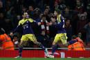 Swansea City's English midfielder Leon Britton (L) runs to celebrate after causing Arsenal's French midfielder Mathieu Flamini to score an own goal at the Emirates Stadium in London on March 25, 2014