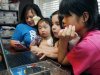 In this April 4, 2013 photograph, the Smith women, from left, mother Niki Smith, GiGi, 3, Macy Jade, 7 and Guan Ya, 14, use Google Translate on the family laptop to "speak" with their new daughter, Guan Ya, in their Rienzi, Miss., home. The Smiths and their children are using the Google Translate program to communicate almost exclusively with Guan Ya, who is deaf. The family uses iPhones, iPods and a laptop, all loaded with the program to write in either English that translates to Chinese or vice-a-versa. (AP Photo/Rogelio V. Solis)