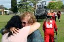 Evacuees formerly stranded in the earthquake-affected town of Kaikoura stand alongside the helicopter that brought them to the town of Woodend