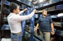 An Iranian man looks at a pair of jeans at shop in Tehran on October 7, 2013