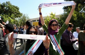 Supporters of Iranian president Hassan Rouhani hold …