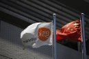 A flag bearing the logo of GlaxoSmithKline flutters next to a Chinese national flag outside a GlaxoSmithKline office building in Shanghai