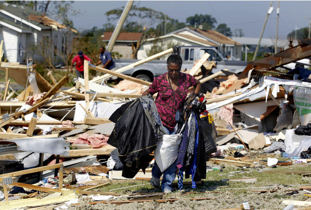 Janie Gibbs helps clean up a friend's destroyed home Sunday, Aug. 28, 2011 after it was hit by Hurricane Irene Saturday in Columbia, N.C.  The storm killed at least 14 people and left 4 million homes 