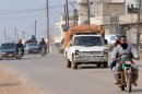 Residents drive motorcycles and cars to flee during fighting close to Hama, on January 27, 2013