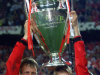 FILE - In this May 26, 1999, file photo, Manchester United's Teddy Sheringham, left, and David Beckham celebrate with the trophy after defeating Bayern Munich 2-1 to win the UEFA Champions League soccer final in Barcelona. Sheringham's goal in the 91st minute and Ole Gunnar Solksjaer's in the 93rd caused Manchester United's comeback to be considered one of the all-time greatest in sports history. (AP Photo/Camay Sungu, File)