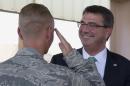 U.S. Defense Secretary Ash Carter is saluted by a member of the U.S. military as he visits and hands out Challenge Coins at a Jordanian air base, Tuesday, July 21, 2015. Carter was at the air base to meet with U.S. and Jordanian troops and coalition officials involved in the fight against the Islamic State group. (AP Photo/Carolyn Kaster, Pool)