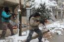 Rebel fighters hold their weapons as they stand amidst snow during clashes with Syrian pro-government forces in the Salaheddin neighbourhood of Syria's northern city of Aleppo on December 11, 2013