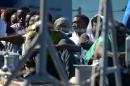 Migrants arrive on a boat of the Armed Forces of Malta after being transferred from the USS San Antonio on October 17, 2013 in Valetta