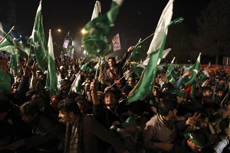 Supporters of Muhammad Tahirul Qadri, leader of Mihaj-ul-Quran wave Pakistani flags during a protest in Islamabad January 14, 2013.Thousands of Pakistanis converged on the capital on Monday to join a march planned by Sufi cleric Qadri calling for the indefinite delay of elections and a crackdown on government corruption and inefficiency. REUTERS/Zohra Bensemra (PAKISTAN - Tags: POLITICS RELIGION CIVIL UNREST)