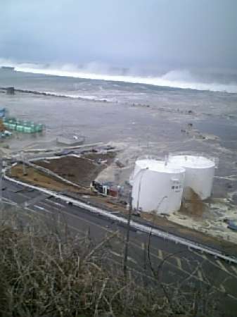 Tsunami waves approach the Tokyo Electric Power Co.'s Fukushima Daiichi nuclear power plant in Fukushima Prefecture