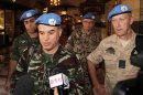 Moroccan Col. Ahmed Himmiche, foreground, is flanked by other U.N. observers as he talks to journalists before leaving the Sheraton Hotel in Damascus, Syria, Monday, April 16, 2012. An advance team of U.N. observers on Monday was working out with Syrian officials the ground rules for monitoring the country's 5-day old cease-fire, which appeared to be rapidly unraveling as regime forces pounded the opposition stronghold of Homs with artillery shells and mortars, activists said. (AP Photo/Bassem Tellawi)