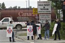 Picketers stand at the entrance to the CP Rail yards in Coquitlam