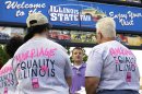 In this Wednesday, Aug. 14, 2013 photo, Randy Hannig, center, of Equality Illinois, hands out shirts supporting gay marriage and explains how people can help support the cause during the Illinois State Fair in Springfield, Ill. After their campaign to legalize gay marriage fizzled in Illinois this year, advocates set aside their disappointment and gave their campaign a serious makeover. (AP Photo/Seth Perlman)