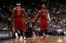 LeBron James (I) y Dwyane Wade, de los Miami Heat, se dan la mano durante el partido de la NBA frente a los Phoenix Suns, el 25 de noviembre de 2013 en Miami