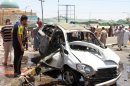 Iraqis inspect the site of a suicide car bomb attack in Samarra, on July 5, 2013