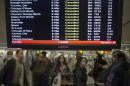 Travellers surround a flight monitor showing cancelled flights at LaGuardia airport in New York