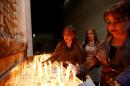 Iraqi Christians light candles during a mass on Christmas eve at Sacred Heart Catholic Church in Baghdad