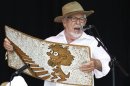 Australian singer Rolf Harris performs with his wobbleboard at the Glastonbury Festival 2010 in south west England
