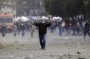A protester opposing Egyptian President Mursi tries to stop riot police from firing tear gas, during clashes in Cairo