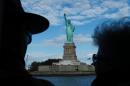 File photo taken in October 2013 shows tourists looking at the Statue of Liberty while on a cruise in the New York harbor