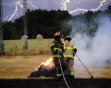 Lightning streaks across the sky while Athens-Clarke Firefighters work to extinguish a hay fire that was caused by a lightning strike, Thursday, May 26, 2011, in Athens, Ga. Firefighters responded to