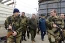 Alexander Zakharchenko (3rd L), leader of self-proclaimed People's Republic of Donetsk, arrives surrounded by gunmen to watch the unloading of a Russian humanitarian convoy as it arrives in the eastern Ukrainian city of Makeyevka on November 16, 2014