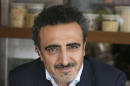 This April 30, 2015 photo provided by Chobani LLC shows company founder and CEO Hamdi Ulukaya at the Chobani Soho cafe in New York. Ulukaya says he will join some of the world's richest individuals in pledging to give away at least half his wealth, which has been estimated at $1.41 billion. (Mark Von Holden/AP Images for Chobani, LLC)