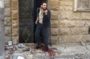 A man reacts as he stands on blood stains at a site hit by airstrikes in the rebel held area of Aleppo's al-Fardous district